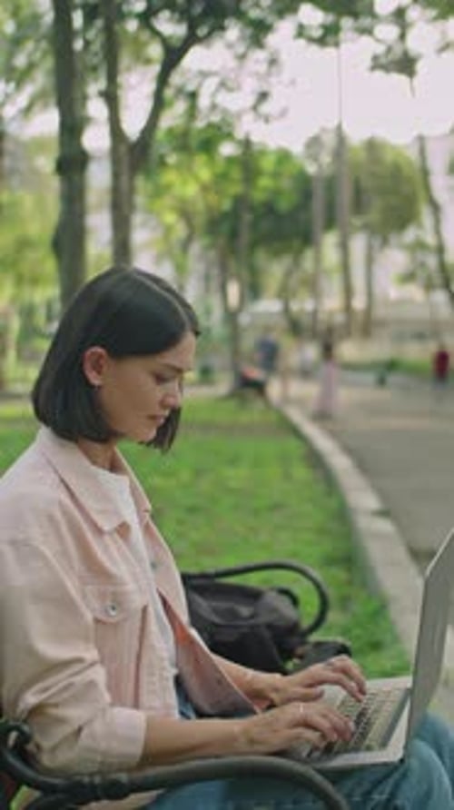 Young Woman Working Online on Laptop in Park