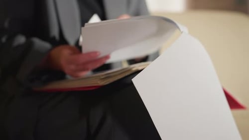 Closeup of Businesswoman Flipping Through Documents in Office Folder