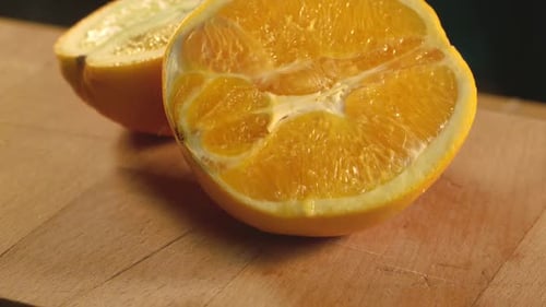 Frische Orangenfruchthälfte. Leckere Orangenscheibe auf Holzuntergrund. Nahaufnahme von Orange Half. Orange...