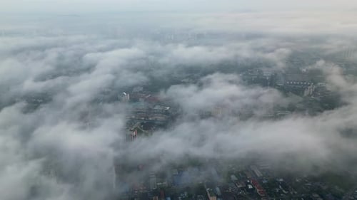 Aerial footage low fog clouds Kuala Lumpur city skyline.
