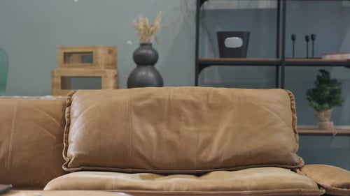 Man Sits on Sofa Opening Laptop