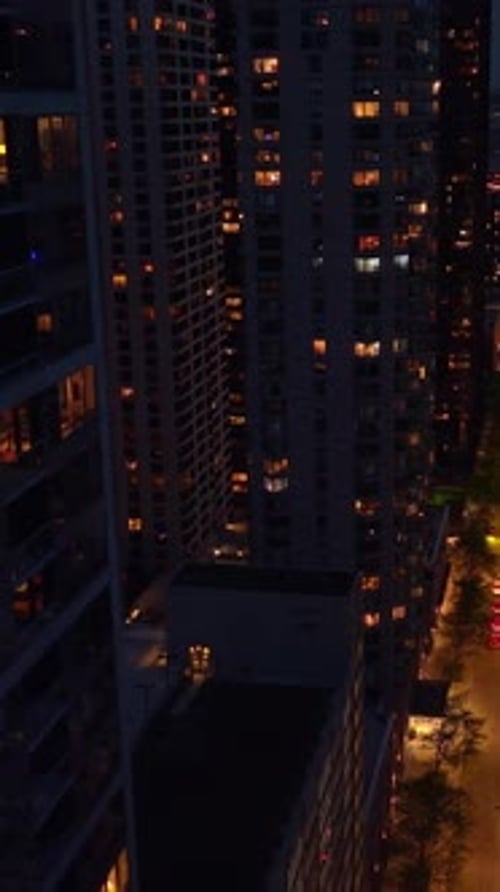 Well-lit street of Chicago downtown at night. Drone footage descending among the stunning skyscraper