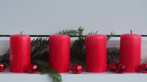 Neujahrs- und Weihnachtsvorbereitung Vier rote Adventskerzen, die auf einer weißen Fensterbank brennen, handgemacht