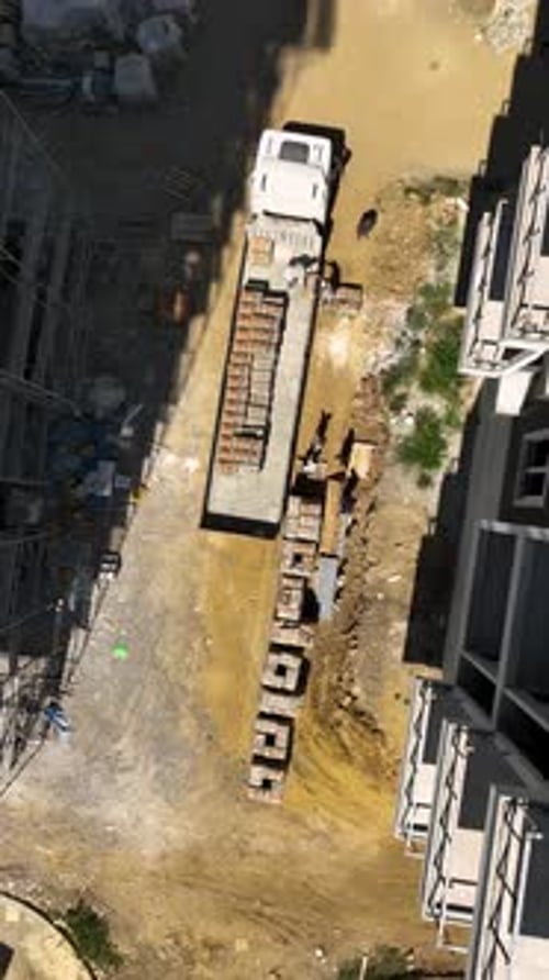 Vertical Video Construction Workers on Scaffolding Fixing Exterior Panels on a HighRise Residential