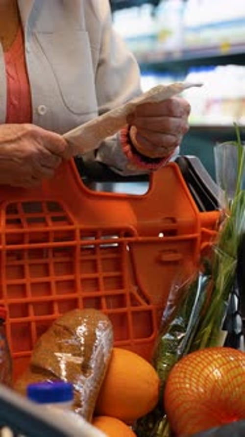 CloseUp of Senior Woman Checking Receipt in Grocery Store