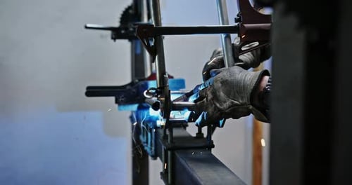 Der Schweißer in der Werkstatt fertigt und verbindet Metallkonstruktionen, der Arbeiter in der Schutzwerkstatt