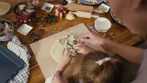 Child and Adult Making Christmas Cookies Together