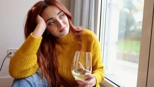 Woman with Wine Sitting by Window