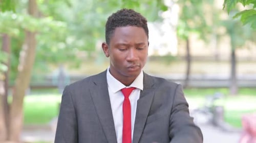 Man in Suit Checking Time in Urban Park