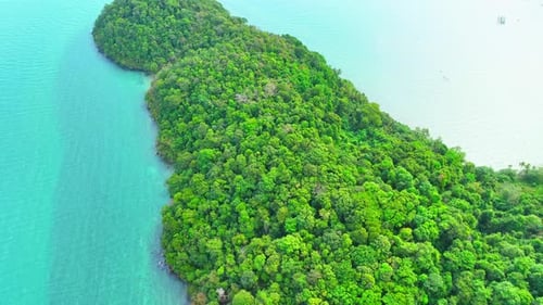 Aerial view reveals a paradise island with lush rainforests in Thailand.