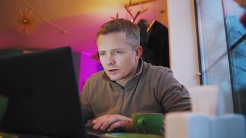 Portrait of a Freelancer Working in a Cafe Using a Laptop Owner of a Small Business Works An Adult