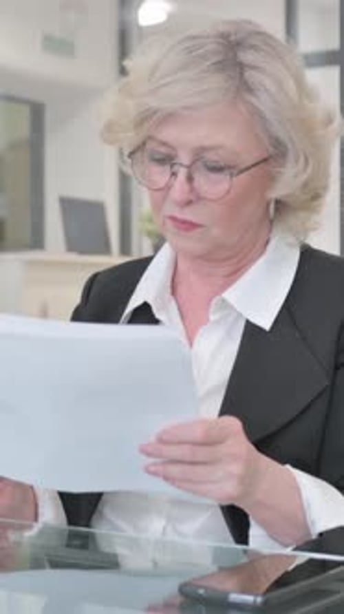 Woman Reviews Documents in Brightly Lit Office Environment