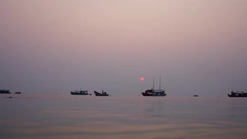 View From the Sea of Boats in the Background of a Sunset