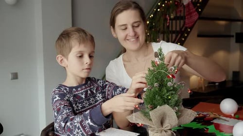 Woman and Child Decorating Christmas Tree with Lights