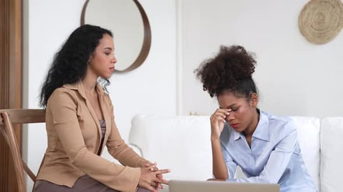 Worried Woman Consoling Sad Friend in Home Setting