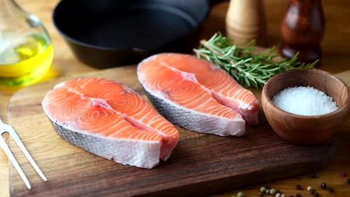 Raw Salmon Steaks on Wooden Cutting Board