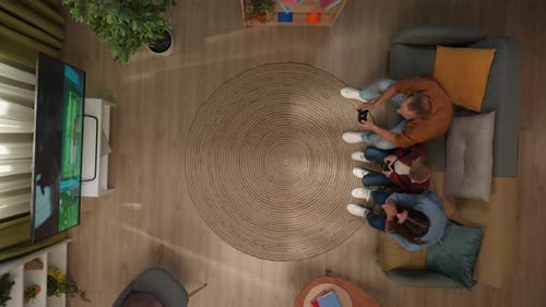 Top View of Living Room Mother Father and Son Sitting on the Sofa Playing Video Game and Having Fun