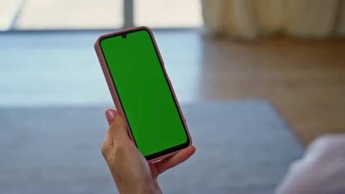 Woman Using Smartphone with Green Screen Indoors