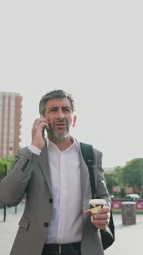 Businessman Talking on Phone While Walking Outside