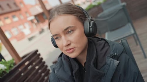 Woman with Headphones Close Up Outside in Urban Setting