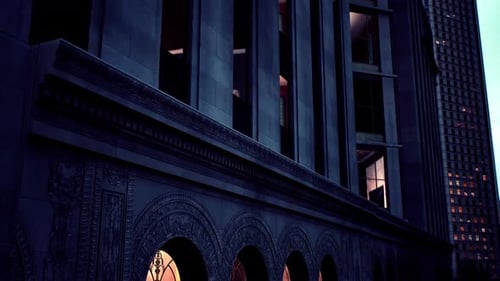Historic Building at Dusk with Illuminated Arches and Modern Architecture