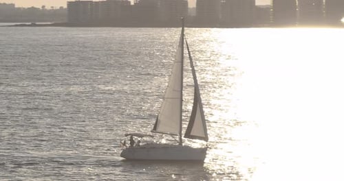Sailboat Gliding on Ocean at Sunrise