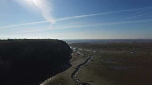 Aerial view of a coastal cliff looking out to sea, in the English Lake District, on a bright and sun