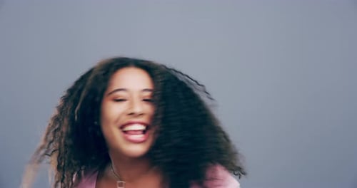 Excited Woman with Curly Hair Dancing in Studio