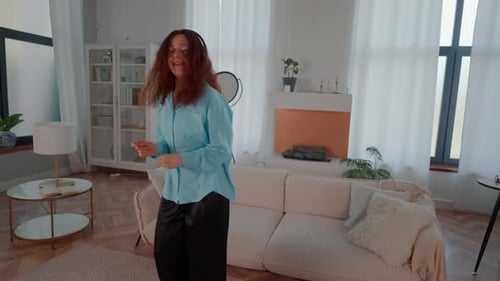 Woman with Headphones Dances at Home