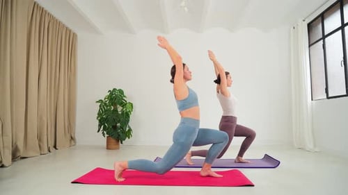 Women Performing Yoga Positions in a Bright Studio
