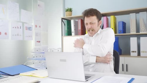 Man in Office Rubbing Aching Shoulder