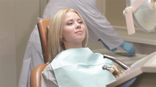 Woman Smiling at Dentist in Clinic Exam Room