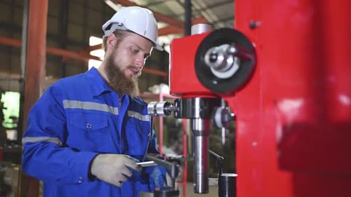 Engineer Inspecting Metal Part at Factory Workplace