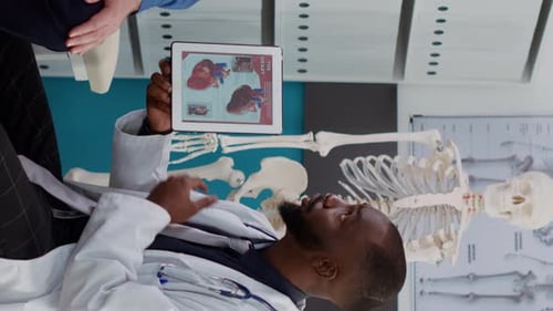 Doctor Reviews Heart Illustration on Tablet with Patient