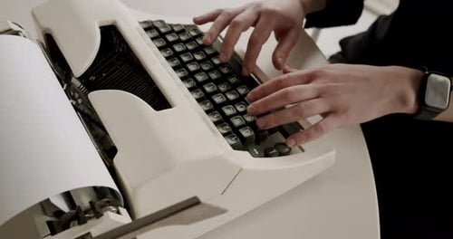 Person Typing on a Vintage Typewriter Keyboard