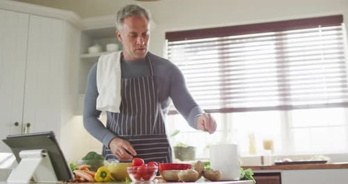 Man Prepares Vegetables Using Kitchen Tablet