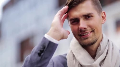 Happy young man smiling outdoors on a city street in slow motion