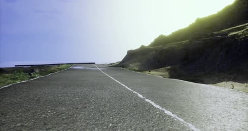 Sunny Road Winding Through Mountainous Landscape During Midday Conditions