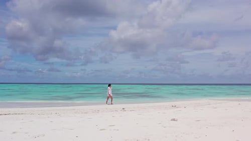 Girl Walking on a White Sand Beach in the Maldives