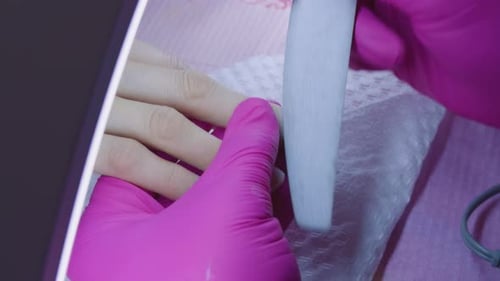 Manicurist filing her client's nails at home. Home care. Close-up shot