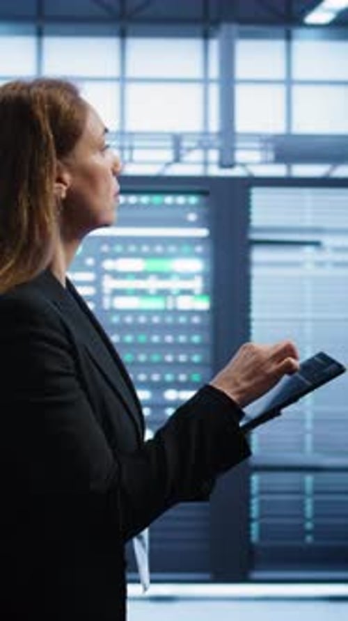 Vertical Video Technician Doing Yearly Checkup Using Tablet to Preserve Data Center Electronics