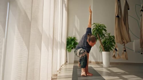 Man Doing Yoga Exercise Inside Bright, Peaceful Studio