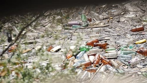 Schwimmende Plastikflaschen und verschiedener Müll in verschmutztem Wasser