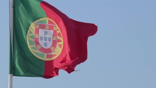 Drapeau national du Portugal flottant dans le vent par temps clair et ensoleillé à Blue Sky Real Footage Selective