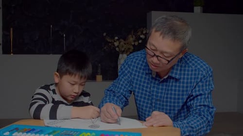 Handsome Asian Grandfather and Grandson Enjoying Drawing Together at Home