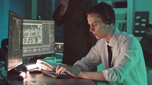 Security Officer Monitoring Satellite Footage of Target in Control Room