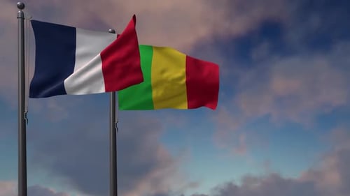 French and Malian Flags Waving Against a Cloudy Sky