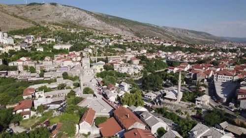 Picturesque Mostar nestled among mountains, showcasing architecture. Aerial