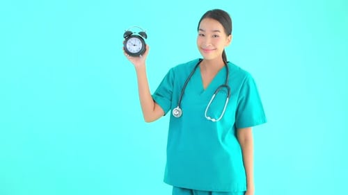 Woman in Scrubs Holding Alarm Clock