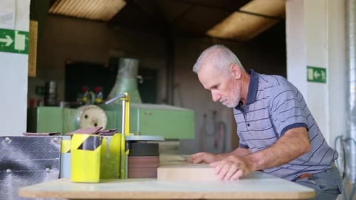 Senior Man Working with Woodworking Machine in Workshop